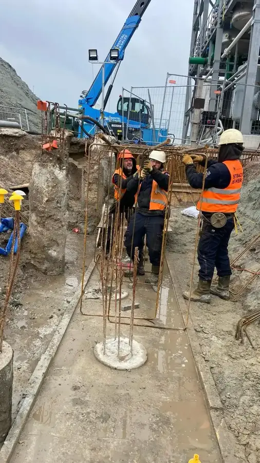 Funderingssleuven met bekisting, windmolens op de achtergrond
