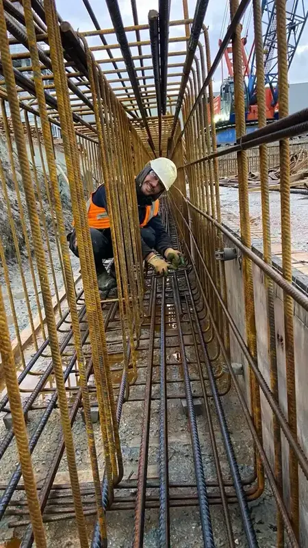 IJzervlechter aan het werk in een diepe wapeningssleuf tussen de wapeningswanden