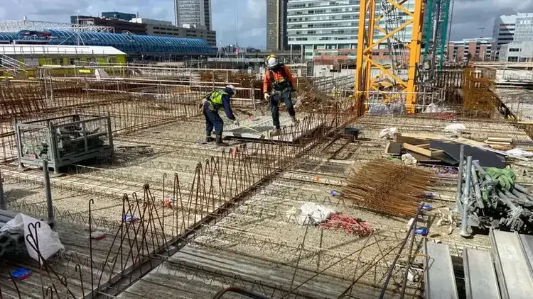 Vloerwapening met bekisting, twee vlechters en kraan met de Den Haag skyline
